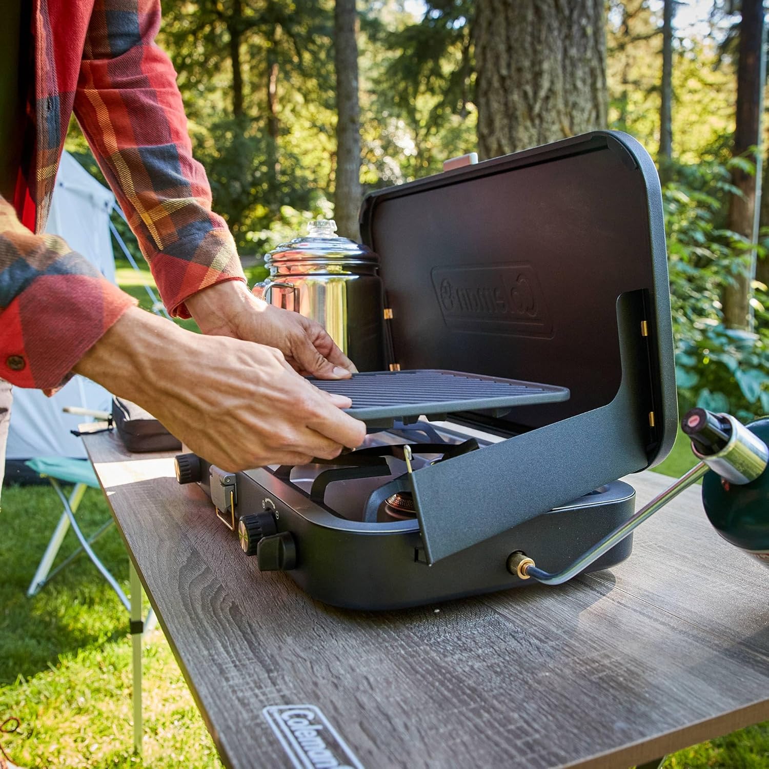The 1900 series three-in-one propane camping stove. featuring a cast iron grill and frying pan accessories. has a power output of 24000 watts. It is equipped with an adjustable flame cover and excellent lighting device. and comes with two adjustable
